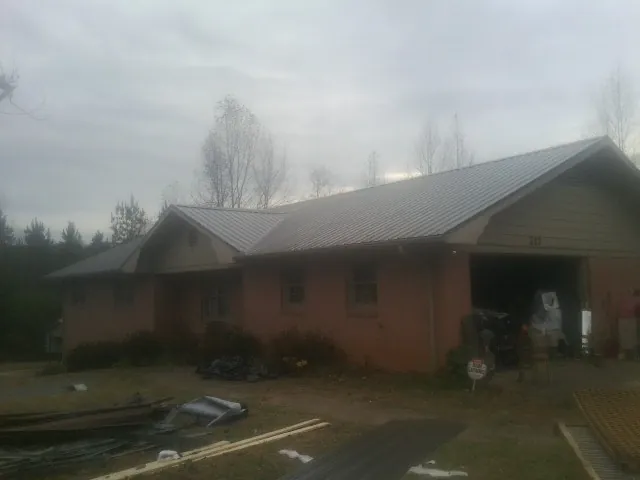 Gray metal roof on a stucco house with an attached garage in Rockport